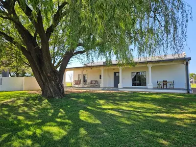 a house with a tree in the yard at Oudezwaanskraal Game Farm in Waaikraal