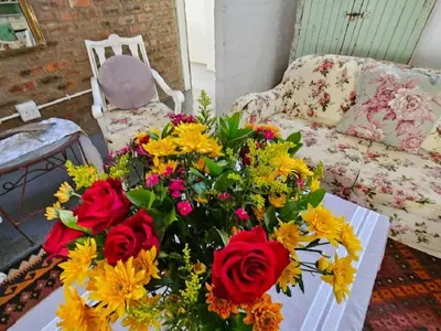 a vase of flowers on a table in a living room at Oudezwaanskraal Game Farm in Waaikraal
