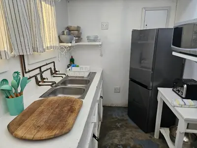 a kitchen with a sink and a wooden cutting board at Oudezwaanskraal Game Farm in Waaikraal