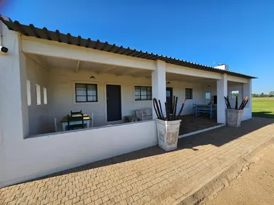 a white house with a porch with a patio at Oudezwaanskraal Game Farm in Waaikraal