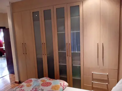 a large wooden cabinet with glass doors in a bedroom at 4C On Gillian in Sandton