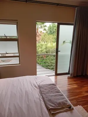 a bedroom with a bed and a sliding glass door at 4C On Gillian in Sandton