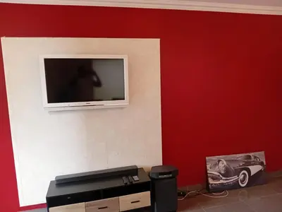 a television on a wall with a red wall at 4C On Gillian in Sandton