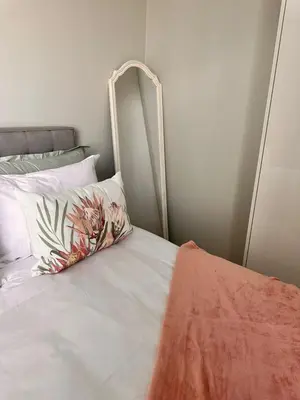 a white bed with a flower pillow on it at 2115 Kepler, Ellipse - Serene Luxury in Midrand