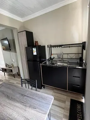 a kitchen with a black refrigerator and a table at Galpinii House in Pretoria