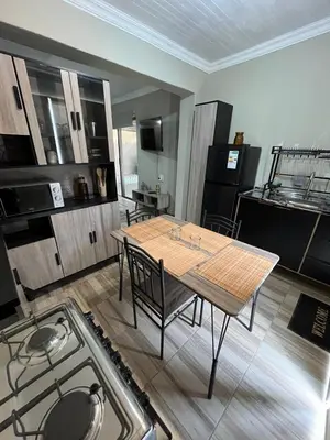 a kitchen with a table and chairs in a room at Galpinii House in Pretoria