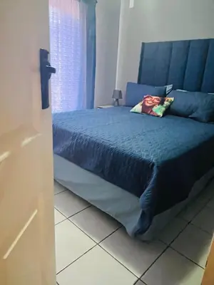 a bedroom with a bed with a blue comforter at 2 Spacious bedroom apartment in Ellisras