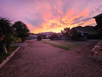 an empty brick road with a sunset in the background at Malala Lodge in Lorraine