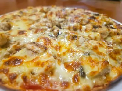 a pizza sitting on top of a plate on a table at Malala Lodge in Lorraine