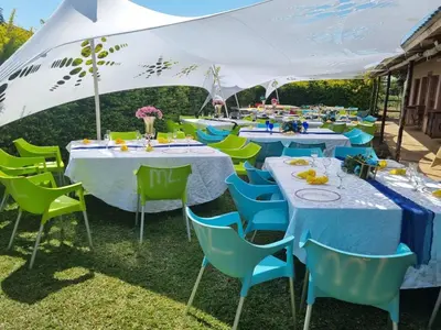 a group of tables with blue and green chairs at Malala Lodge in Lorraine