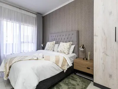 a bedroom with a large bed and a window at Binbin Home Away From Home in Midrand