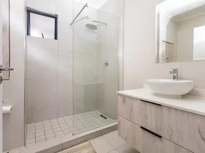 a white bathroom with a sink and a shower at Binbin Home Away From Home in Midrand