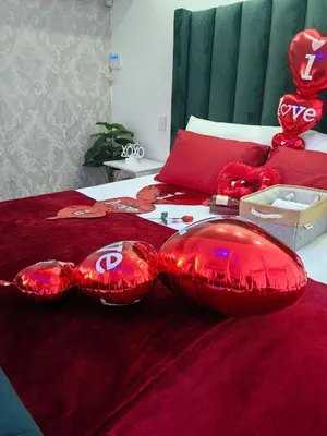 two red pillows on a bed with red sheets at Tabularasa Hideaway in Pretoria