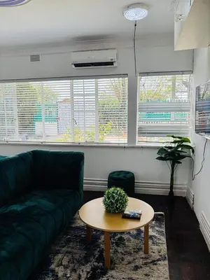 a living room with a green couch and a table at Tabularasa Hideaway in Pretoria