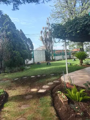 a garden with a lawn and a park with trees at Tabularasa Hideaway in Pretoria