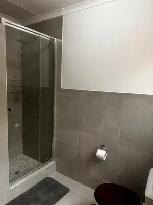 a bathroom with a shower with a toilet and a roll of toilet paper at 49 Bela-Bela Pendleberry Grove Holiday Unit 49 in Warmbaths