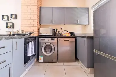 a kitchen with a washing machine and a washer at Ridge Comfort in Midrand