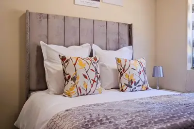 a bedroom with a large bed with pillows at Ridge Comfort in Midrand