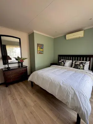 a bedroom with a large bed and a mirror at Gallery Grove in Pretoria