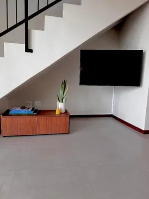 a room with a flat screen tv and a table at Gallery Grove in Pretoria
