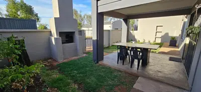 a patio with a table and chairs in a yard at Meander Sky in Centurion