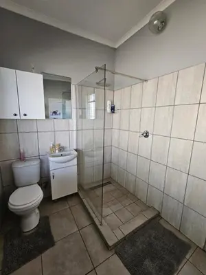a bathroom with a toilet and a glass shower at Meander Sky in Centurion