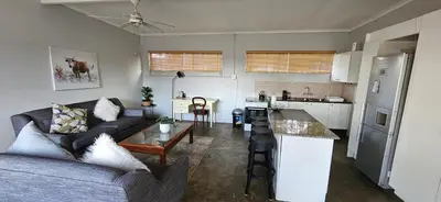 a living room with a couch and a kitchen at Meander Sky in Centurion