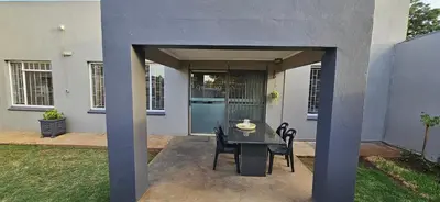 a patio with a table and chairs in front of a house at Meander Sky in Centurion