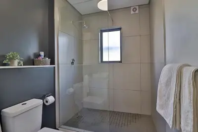 a bathroom with a shower and a toilet at Lethukukhanya Luxury Apartment in Nelspruit