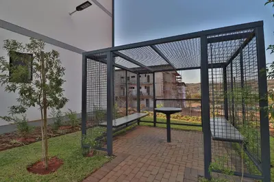a batting cage with a bench and a tree at Lethukukhanya Luxury Apartment in Nelspruit