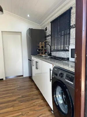 a kitchen with a washing machine in a room at The Hideaway Cabin in Pretoria