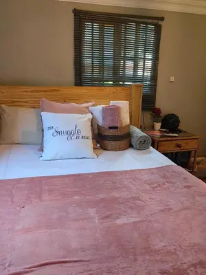 a bedroom with a large bed with pillows on it at The Hideaway Cabin in Pretoria