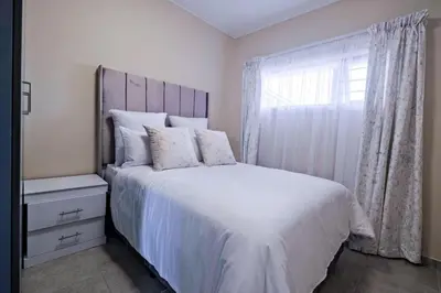 a bedroom with a large white bed with a window at Diamond Hill in Midrand
