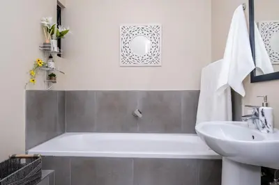 a bathroom with a white tub and a sink at Diamond Hill in Midrand