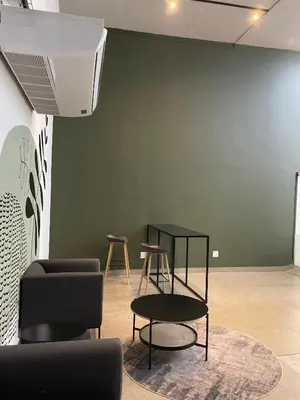 a room with chairs and tables and a green wall at Circa Aparthotel by unit 187 in Pretoria
