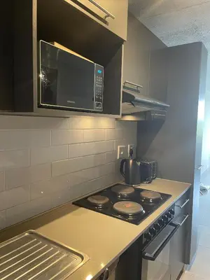a kitchen with a stove top oven with a microwave at Circa Aparthotel by unit 187 in Pretoria
