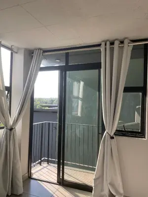 a window with curtains in a room with a balcony at Circa Aparthotel by unit 187 in Pretoria
