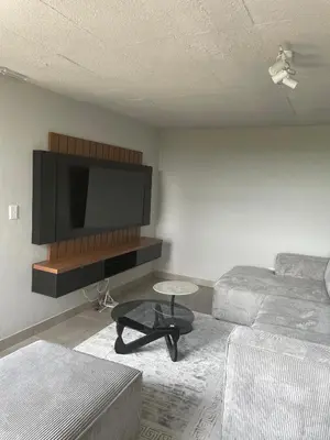 a living room with a couch and a flat screen tv at Circa Aparthotel by unit 187 in Pretoria