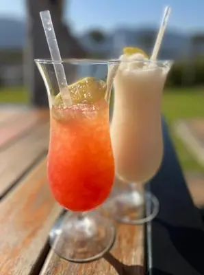 two cocktails in glasses sitting on a wooden table at Pecanwood Paradise in Hartbeespoort