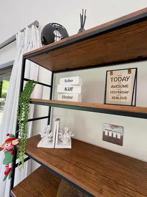 a shelf in a living room with wooden shelves at Pecanwood Paradise in Hartbeespoort