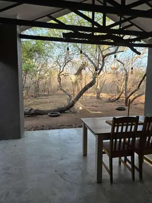 a table and two chairs in a room with a view at Ratel Katel in Marloth Park