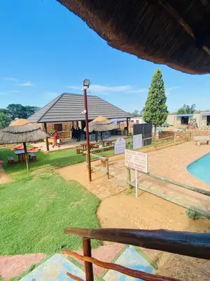 a park with tables and umbrellas and a pool at Graceland Recreation in Erasmus