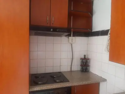 a small kitchen with a stove and brown cabinets at Graceland Recreation in Erasmus