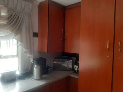 a kitchen with wooden cabinets and a microwave and a window at Graceland Recreation in Erasmus