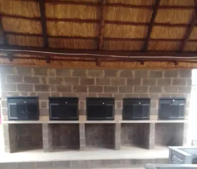 a row of four microwaves on a brick wall at Graceland Recreation in Erasmus