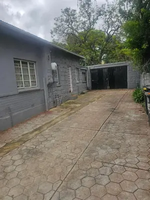 an empty driveway next to a building with a garage at American horses in Pretoria