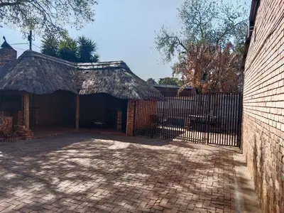 a gate to a building with a thatch roof at American horses in Pretoria