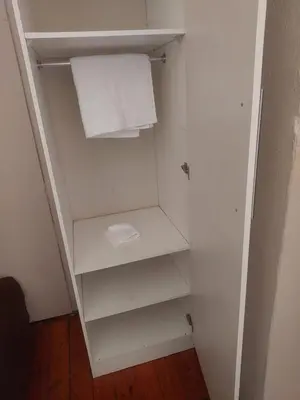 an empty closet with white shelves and a towel at American horses in Pretoria