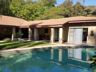 a house with a swimming pool in front of it at Santai guesthouse in Brits