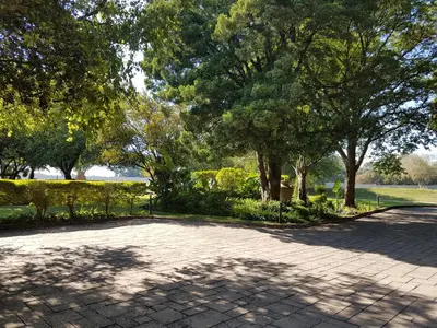 a walkway in a park with trees and a sidewalk at Santai guesthouse in Brits